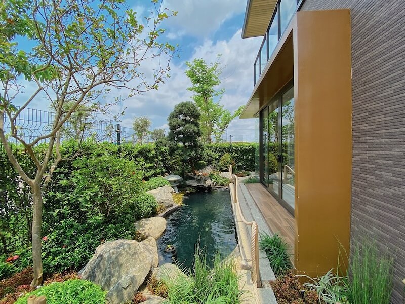 Không gian bên hông nhà được tận dụng làm hồ cá koi dài, ôm sát mặt đứng kính tạo hiệu ứng “nước chảy bên thềm”