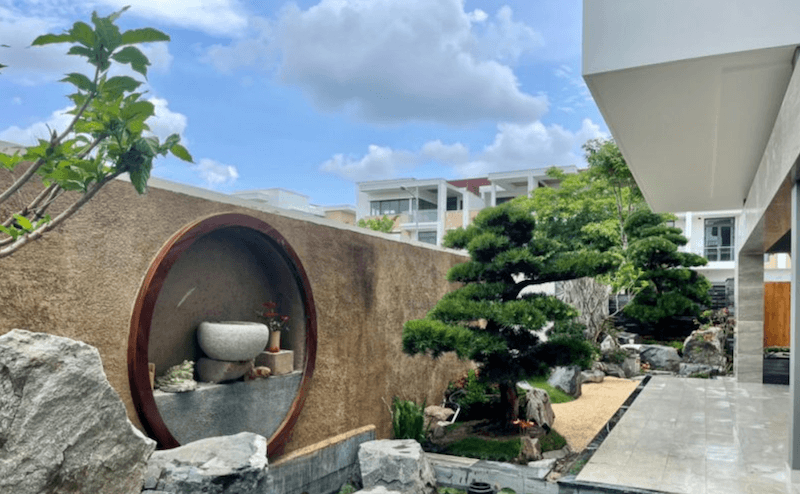 Hốc tường hình tròn mang dáng dấp “cửa nguyệt”, bên trong bố trí bộ bàn ghế đá và bình hoa nhỏ, tạo nên một góc thưởng trà đầy chất nghệ thuật