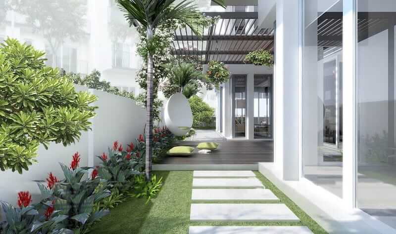 Khu vực sàn gỗ nâng nhẹ so với mặt cỏ, kết hợp ghế thư giãn dáng trứng độc đáo và những chiếc đệm xanh nhạt, tạo nên một góc nghỉ ngơi riêng tư và hiện đại