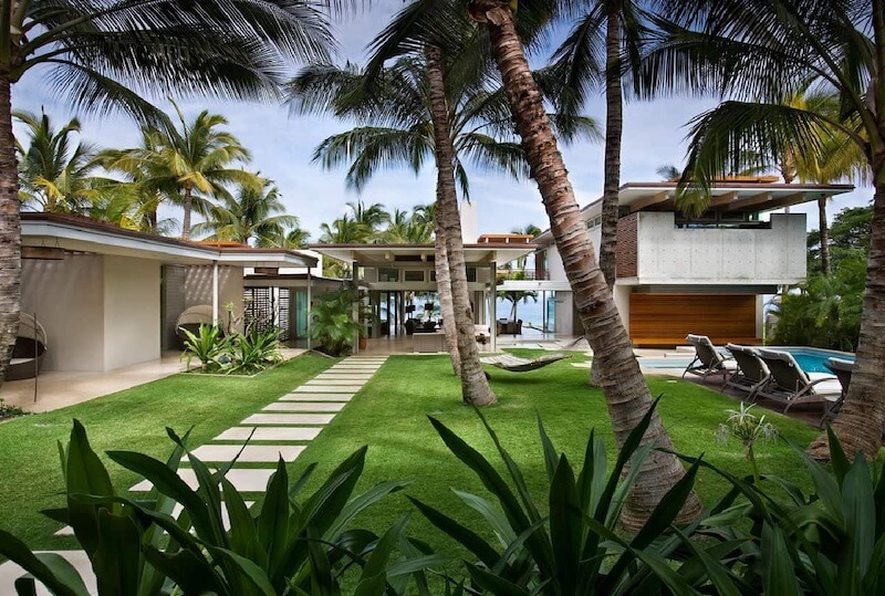 Không gian sân vườn Nhiệt đới gây ấn tượng bởi cây xanh tán rộng, hồ nước mát, vật liệu tự nhiên và không gian mở chan hòa ánh sáng 