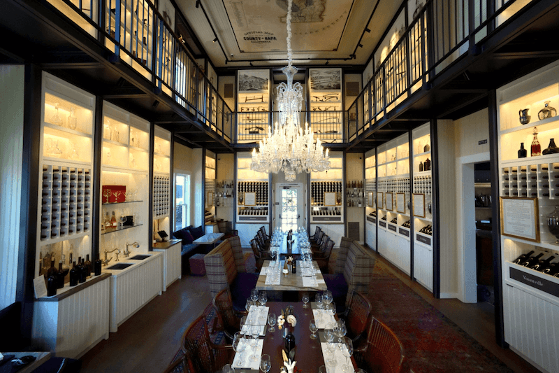 Ánh sáng vàng ấm kết hợp tủ trưng bày kính giúp tôn lên vẻ đẹp của chai rượu, đồng thời mang lại trải nghiệm tinh tế và đẳng cấp cho khách hàng