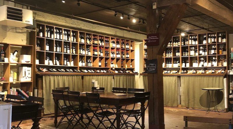 Không gian mang đậm phong cách hầm rượu mộc mạc, sử dụng kệ gỗ chia ô để trưng bày rượu theo chiều ngang, vừa đảm bảo bảo quản vừa tạo cảm giác gần gũi