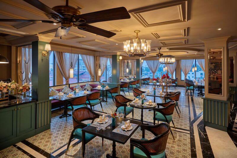 Sự kết hợp giữa cửa kính lớn, rèm vải mềm mại và đèn trang trí cổ điển tạo nên bầu không khí hoài cổ sang trọng, đậm dấu ấn văn hóa Á - Âu