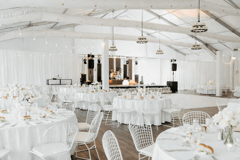 Không gian cưới phong cách Modern High-tech nổi bật với trần thép lộ kết cấu, sân khấu tích hợp âm thanh ánh sáng hiện đại và tông trắng tối giản