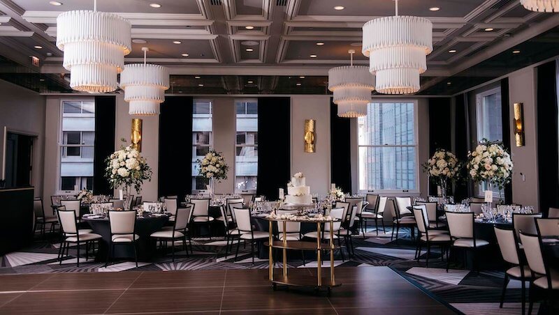 Sảnh cưới ấn tượng với trần ô vuông hiện đại, đèn thả hình học nổi bật, tông đen trắng sang trọng và bố cục không gian tinh gọn