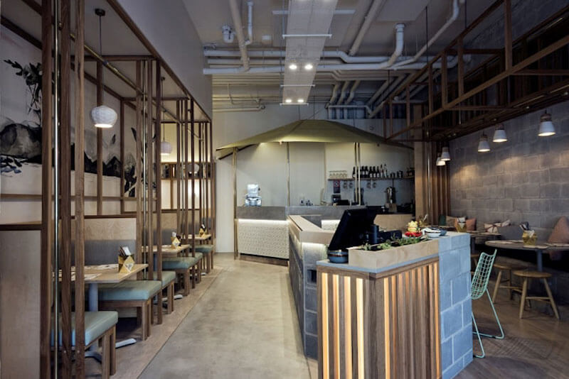 Hệ vách ngăn gỗ dạng khung tạo cảm giác riêng tư cho từng khu bàn nhưng vẫn giữ được sự thông thoáng cho toàn bộ không gian