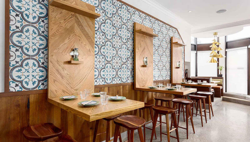 Tường gạch bông họa tiết cổ điển tạo điểm nhấn văn hóa Việt, trong khi nội thất gỗ sáng màu với bàn treo và ghế đẩu thanh gọn mang lại cảm giác hiện đại, tinh tế