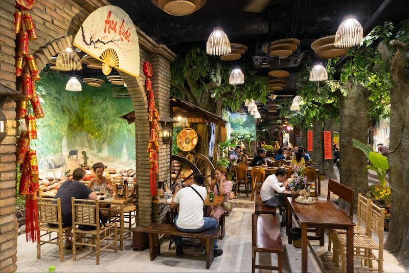 Bức tranh tường tái hiện cảnh đồng quê cùng trâu, lũy tre và ruộng lúa giúp không gian trở nên sống động, gợi nhớ khung cảnh làng quê thanh bình