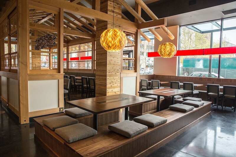 Khu vực bàn ngồi bệt trên sàn nâng tạo trải nghiệm chuẩn văn hóa Hàn, trong khi dãy bàn ghế cao phía ngoài giúp linh hoạt phục vụ nhiều nhóm khách khác nhau