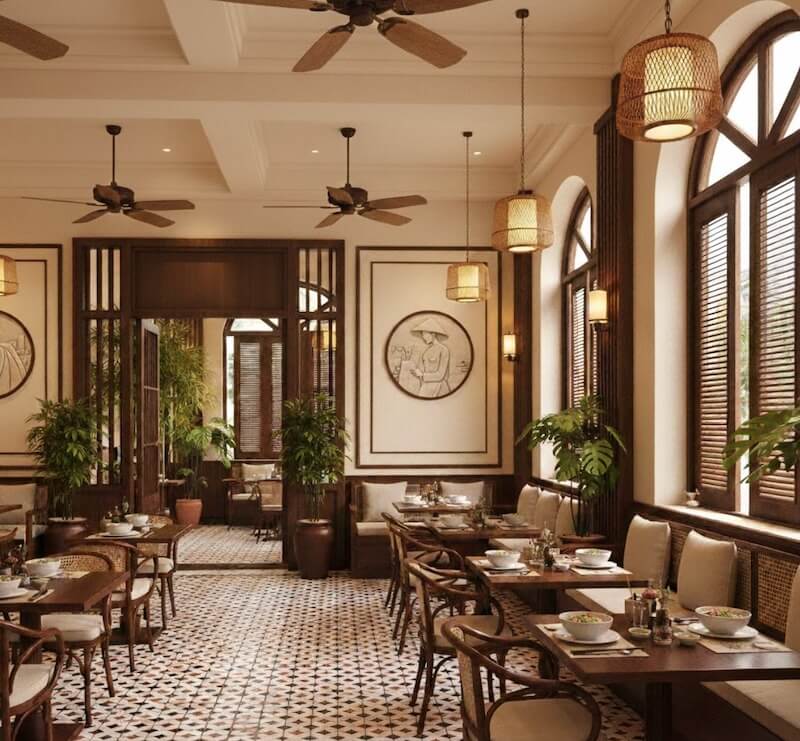 Không gian quán mang hơi hướng Indochine hiện đại với sàn gạch họa tiết cổ điển, bàn ghế gỗ kết hợp mây tạo cảm giác thanh lịch