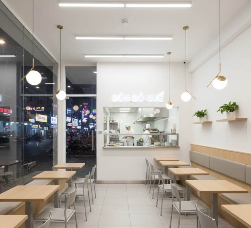 Quán bún bò Huế có thiết kế tối giản với tông trắng sạch sẽ, bếp mở sau kính tạo sự chuyên nghiệp