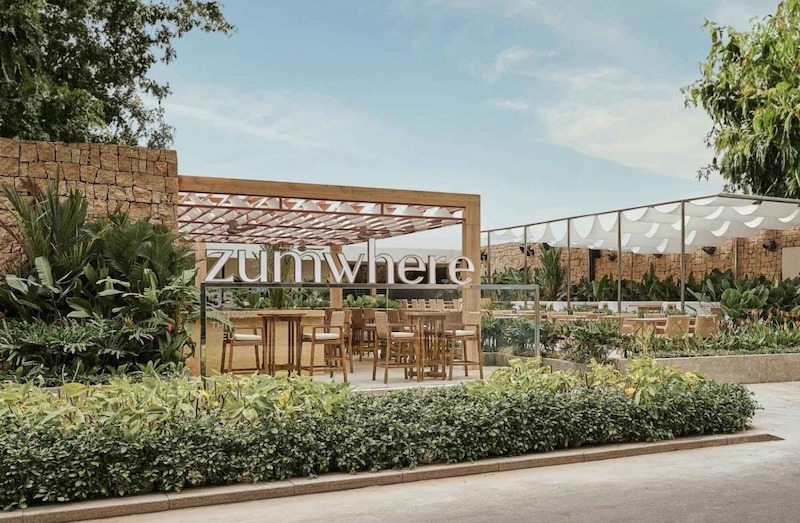 Không gian sân vườn mang cảm giác nghỉ dưỡng với mái pergola gỗ nhẹ, bàn ghế mộc mạc và hệ cây xanh bao quanh tạo sự thoáng đãng, thư giãn