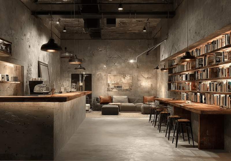 Các góc chill được bố trí với ghế sofa da tối màu hoặc ghế bành, tạo không gian riêng tư giữa quán rộng rãi