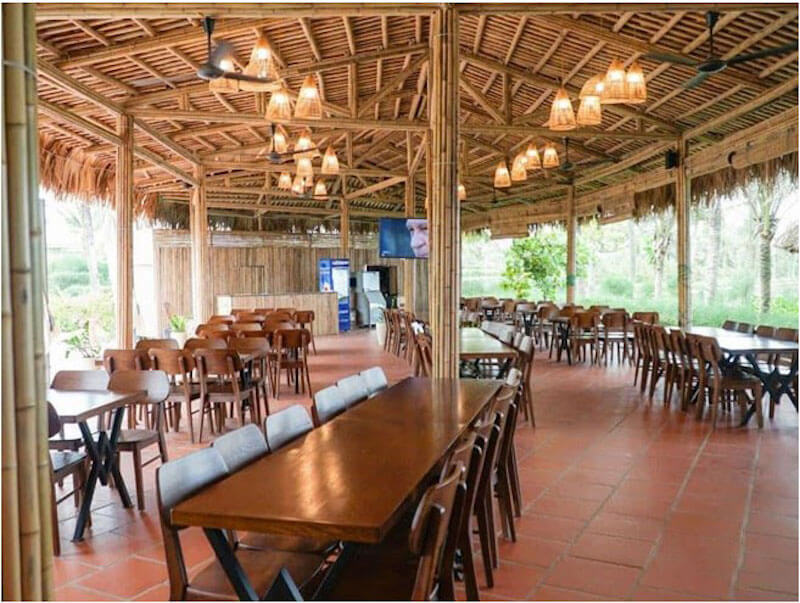 Không gian quán nhậu sử dụng mái lá kết hợp cùng hệ cột tre và ánh sáng lồng đèn dịu nhẹ mang lại cảm giác mộc mạc, gần gũi và vô cùng mát mẻ, dễ chịu