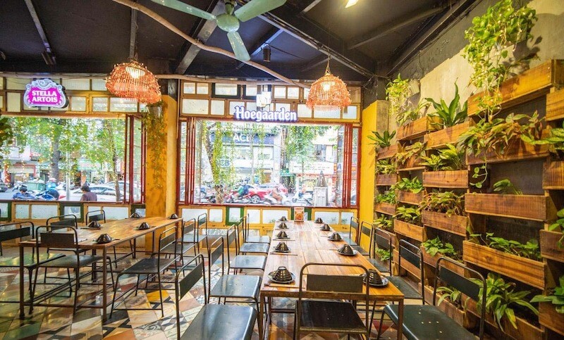 Hệ thống cửa kính lớn tận dụng tối đa ánh sáng tự nhiên để tạo nên một không gian ẩm thực vừa mộc mạc, vừa tràn đầy sức sống