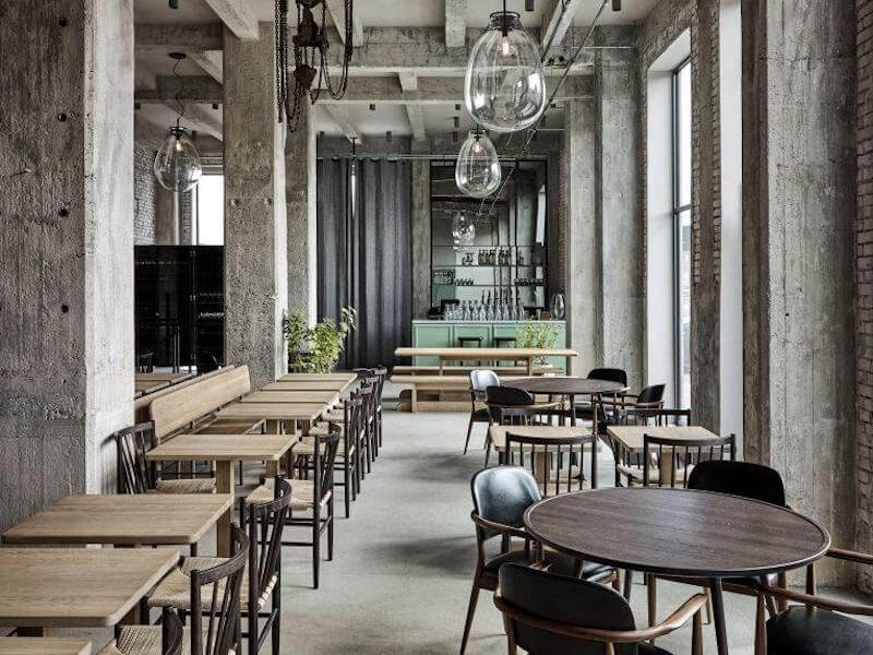 Thiết kế tận dụng kết cấu thô như trần lộ ống kỹ thuật, vừa tiết kiệm chi phí hoàn thiện vừa tạo điểm nhấn độc đáo cho không gian kinh doanh