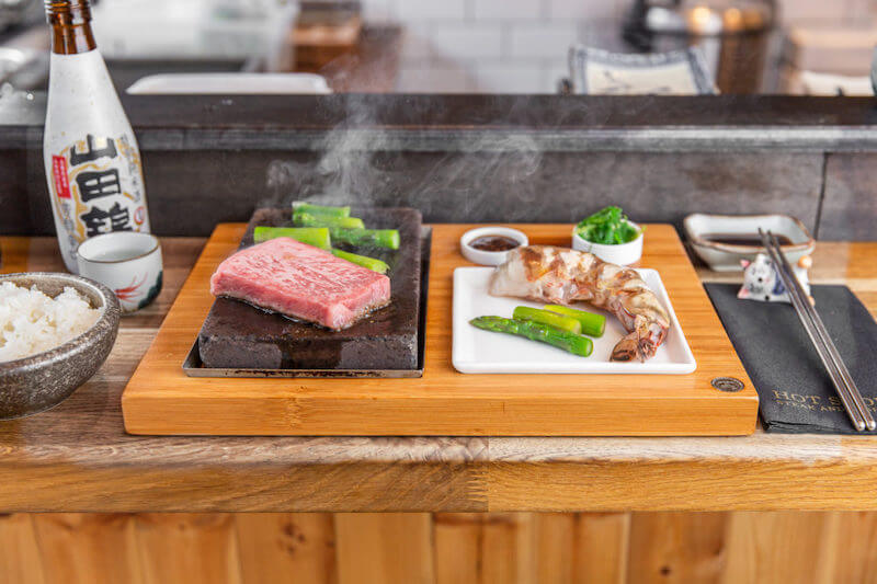 Món bò bít tết được phục vụ trên đá nóng, giúp giữ nhiệt lâu và làm dậy lên hương thơm hấp dẫn khi thưởng thức
