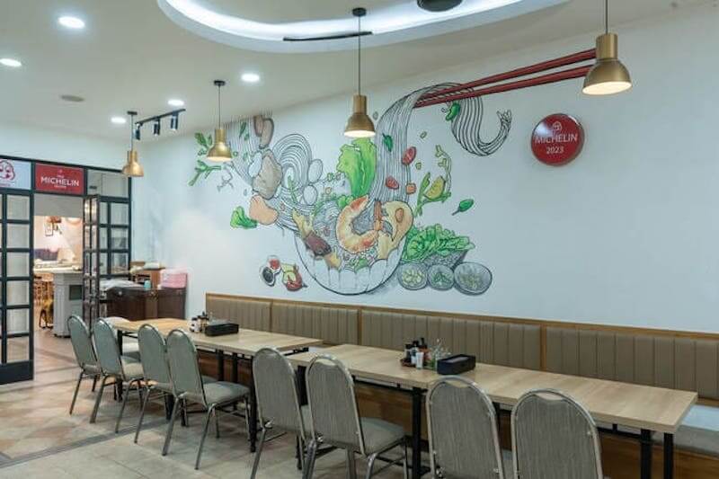 Bức tường nổi bật với tranh minh họa tô hủ tiếu đầy màu sắc, tạo điểm nhấn sinh động và giúp không gian trở nên trẻ trung, dễ nhận diện