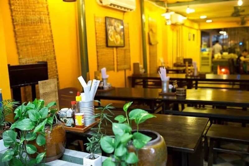 Các chi tiết trang trí như mành tre, chậu cây nhỏ và ánh đèn vàng giúp không gian trở nên sinh động, đồng thời tạo cảm giác sạch sẽ và thoải mái cho thực khách