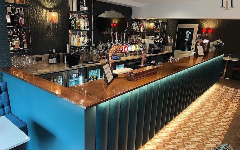 Mặt bàn quầy bar nên sử dụng đá quartz, granite hoặc gỗ phủ epoxy để chống thấm, chống ố màu, bền đẹp và dễ vệ sinh